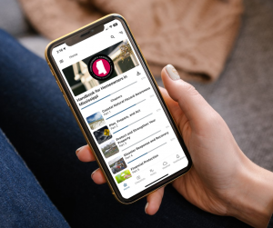 hand holding cellphone with image of Coastal Homeowners Handbook